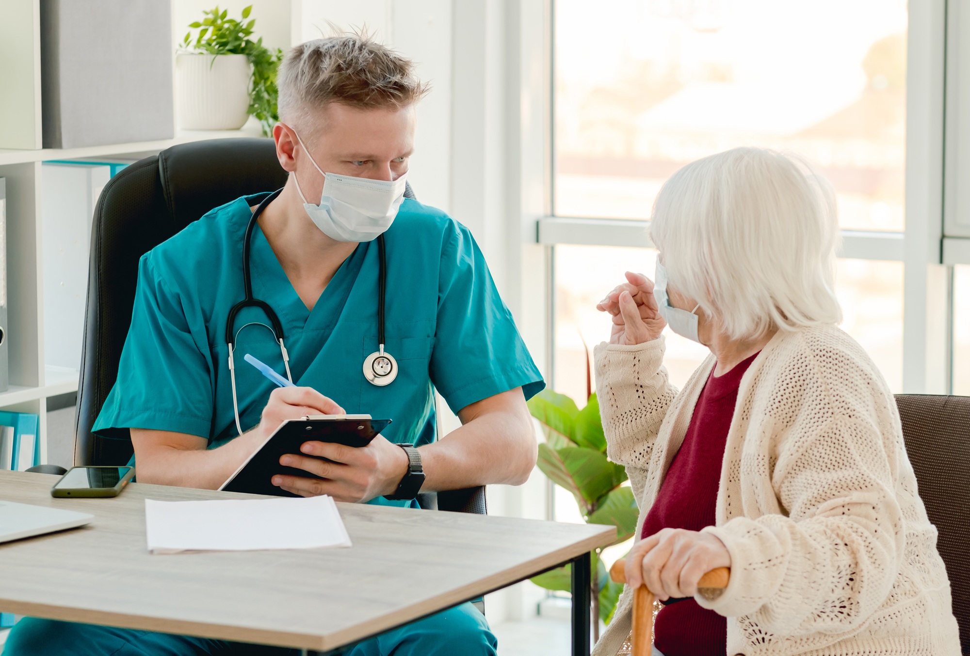 Doctor writing patient complaints during appointment