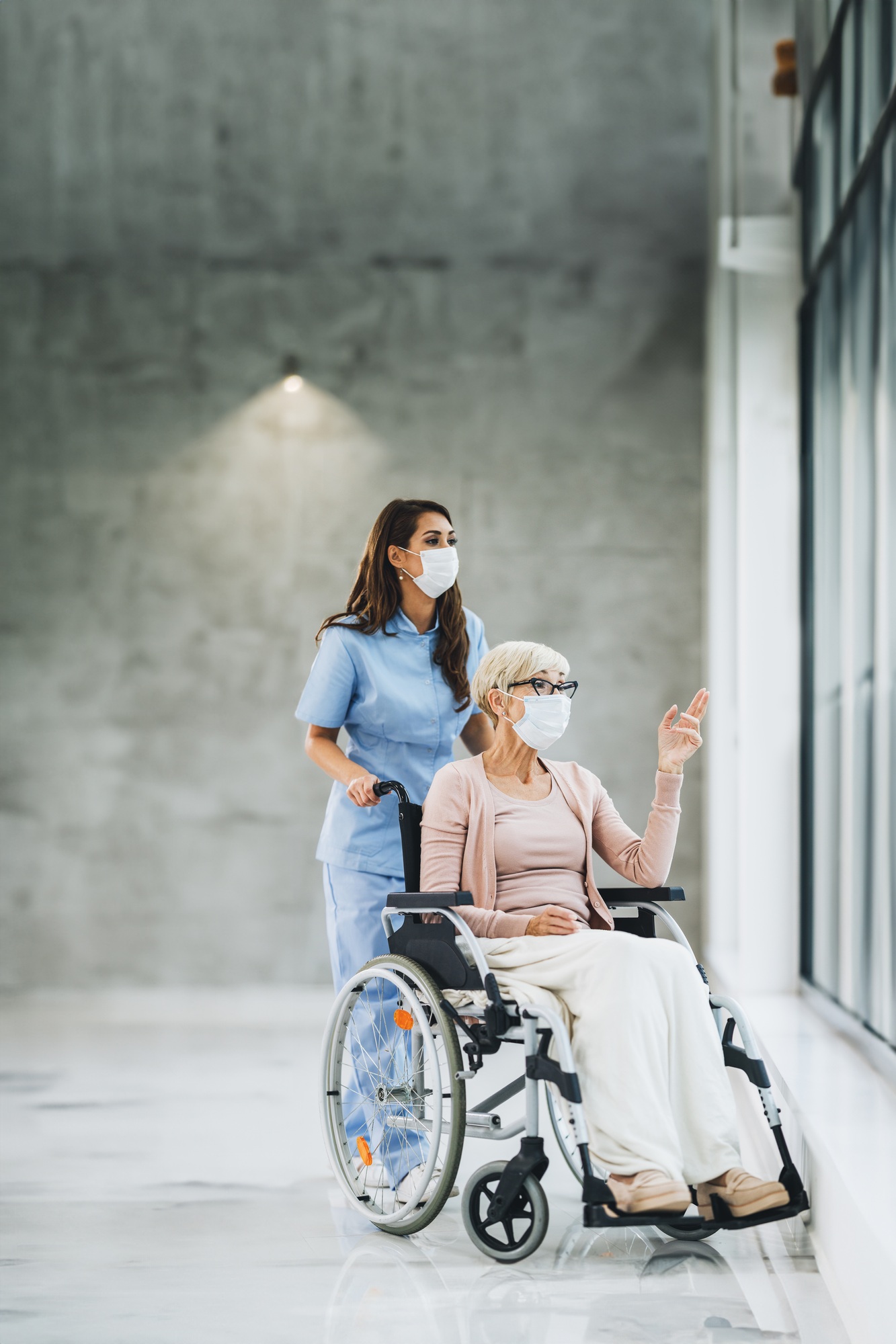 Young Caregiver Caring A Senior Female Wheelchair-Bound Patient